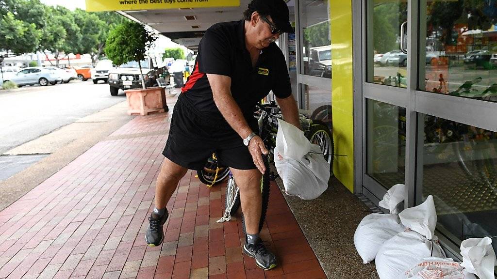Bereit für die Flut, die da kommen könnte: Ladenbesitzer Chris Watt rüstet sein Geschäft im australischen Queensland gegen den Wirbelsturm Debbie.