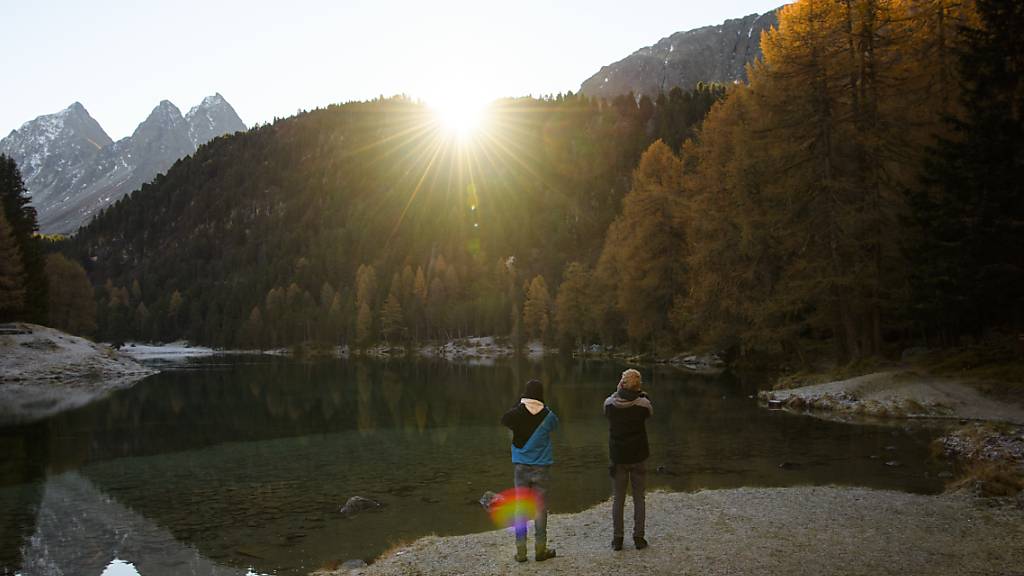 Zwei Jugendliche fotografieren einen Sonnenaufgang: Junge Menschen sollen einen Trend setzen, indem sie klimafreundlich reisen. (Symbolbild)