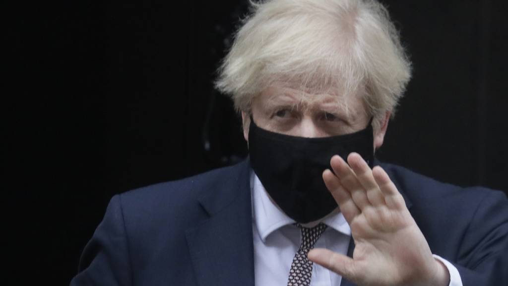 Boris Johnson, Premierminister von Großbritannien, trägt einen Mund-Nasen-Schutz und grüßt beim Verlassen der Downing Street. Foto: Kirsty Wigglesworth/AP/dpa