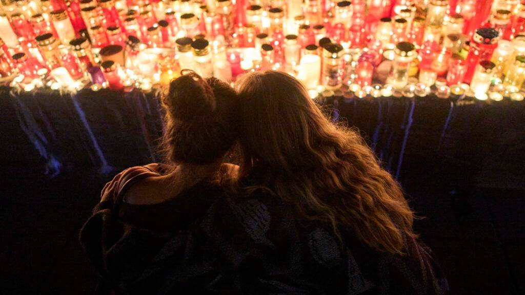 dpatopbilder - Frauen schauen auf Kerzen für die Opfer eines Amoklaufs an einer Schule. Foto: Darko Bandic/AP/dpa