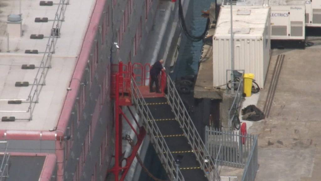 SCREENSHOT - Dieses Standbild aus einem Video der Nachrichtenagentur PA zeigt den Lastkahn «Bibby Stockholm» im Hafen. Nach ihrer umstrittenen Unterbringung auf einem Lastkahn in England haben 39 Migranten die Unterkunft wegen eines festgestellten Krankheitserregers wieder verlassen. Foto: John Gurd/PA Wire/dpa