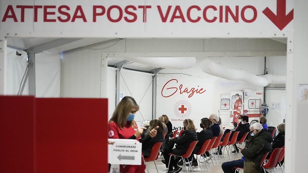 Menschen warten in einem Impfzentrum des Italienischen Roten Kreuzes in Rom. Auf Sizilien haben Ermittler drei Menschen im Zusammenhang mit vorgetäuschten Corona-Impfungen festgenommen. Unter ihnen eine Krankenschwester, die in einem Impfzentrum gearbeitet haben soll. Foto: Gregorio Borgia/AP/dpa