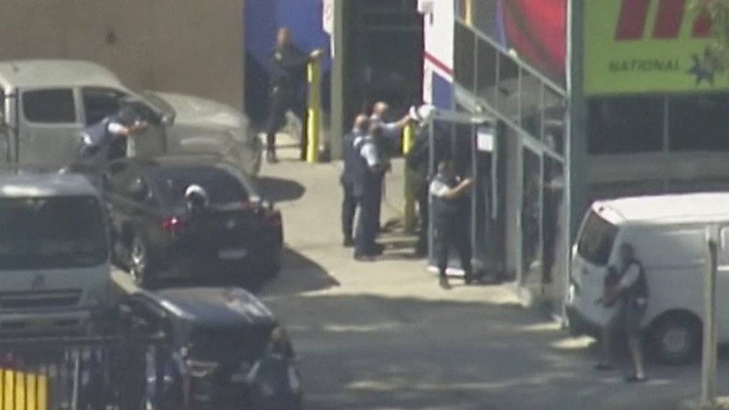 Polizisten gehen vor dem Gebäude in Position, in dem sich der Geiselnehmer verschanzt hatte.