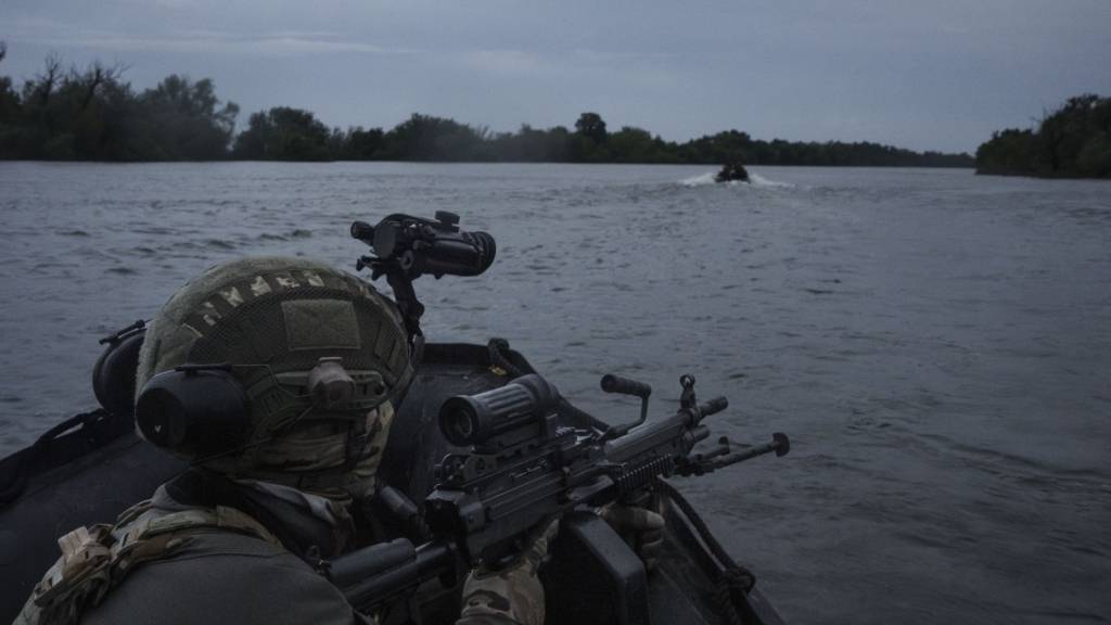 Ukrainische Soldaten fahren mit einem Boot auf dem Fluss Dnipro an der Frontlinie in der Nähe von Cherson. Foto: Felipe Dana/AP/dpa