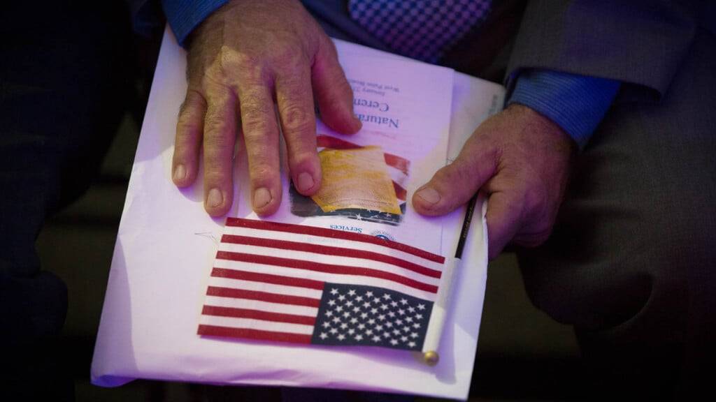 ARCHIV - Ein Einbürgerungsanwärter hält am 23.01.2018 in West Palm Beach (USA) seine Unterlagen und eine kleine US-Flagge. Foto: Allen Eyestone/Palm Beach Post via ZUMA Wire/dpa/Symbolbild