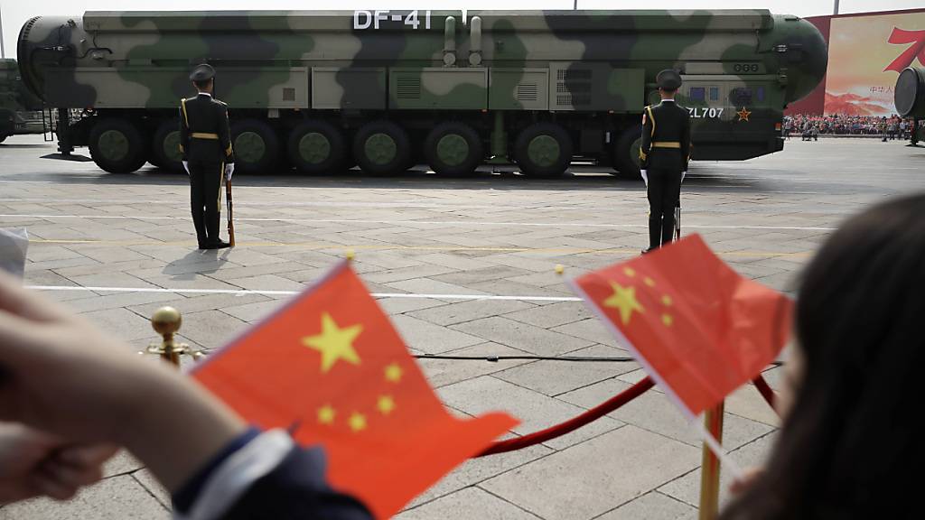 ARCHIV - Zuschauer schwenken chinesische Flaggen, während Militärfahrzeuge mit DF-41-Atomraketen während einer Parade vorbeifahren (Archivbild). Foto: Mark Schiefelbein/AP/dpa