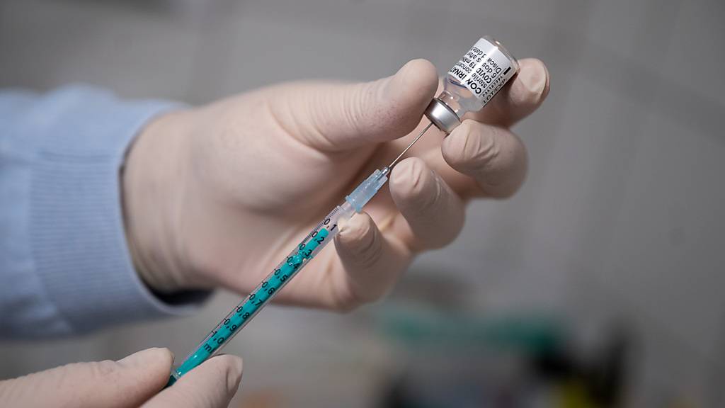 ARCHIV - Ein Arzt zieht in einer Hausarztpraxis eine Spritze mit dem Impfstoff von Pfizer/Biontech auf. Foto: Sebastian Gollnow/dpa