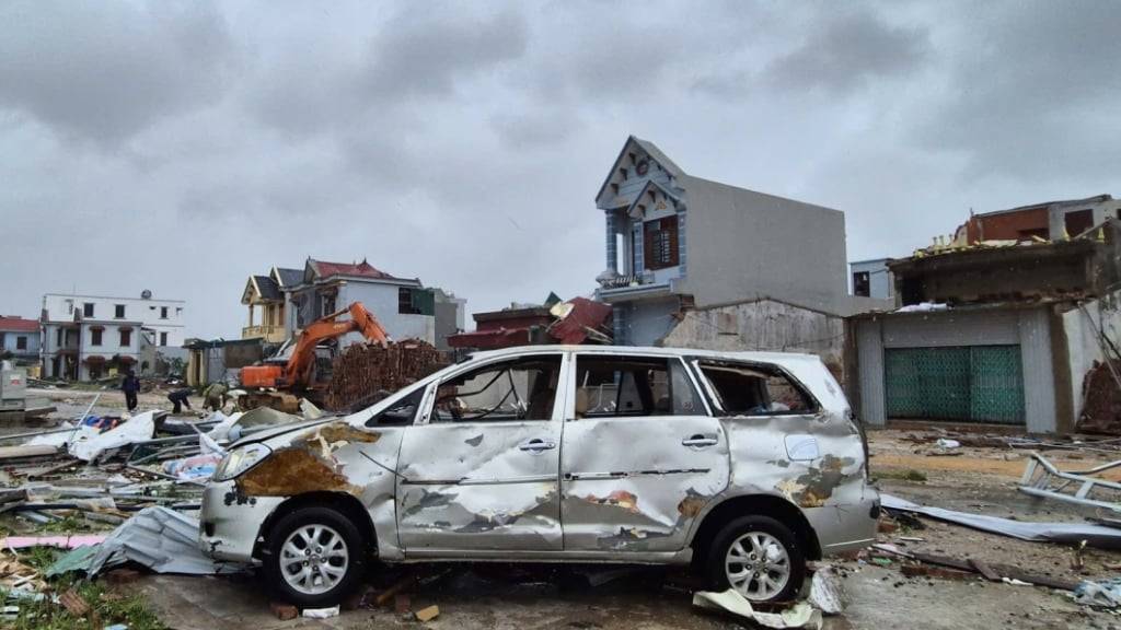 Ein beschädigtes Auto ist inmitten von Trümmern und beschädigten Gebäuden zu sehen, nachdem der Taifun «Bualoi» über die Gegend hinweg gezogen ist. Foto: Viet Hoang/VNExpress/AP/dpa