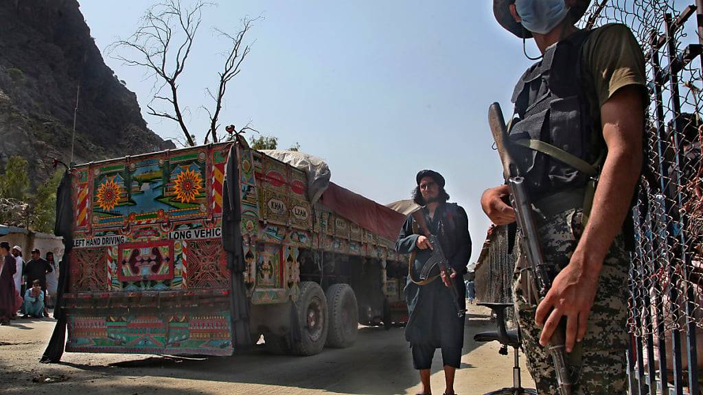 ARCHIV - Ein pakistanischer Soldat (r) und Kämpfer der Taliban stehen Wache an einem Grenzübergang zwischen Pakistan und Afghanistan. Foto: -/AP/dpa