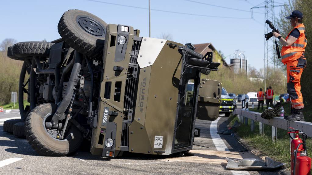Mitglieder der Kantonspolizei und der Militärpolizei untersuchen den umgekippten Duro der Schweizer Armee in Hinwil ZH. (Archivbild)