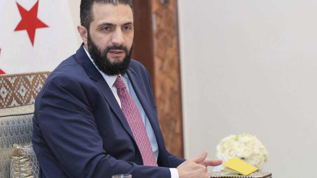 ARCHIV - Auf diesem von der amtlichen syrischen Nachrichtenagentur SANA via AP veröffentlichten Foto erhält der syrische Interimspräsident Ahmed al-Scharaa die endgültige Fassung des vorläufigen Wahlsystems für die Volksversammlung. Foto: Uncredited/SANA/dpa