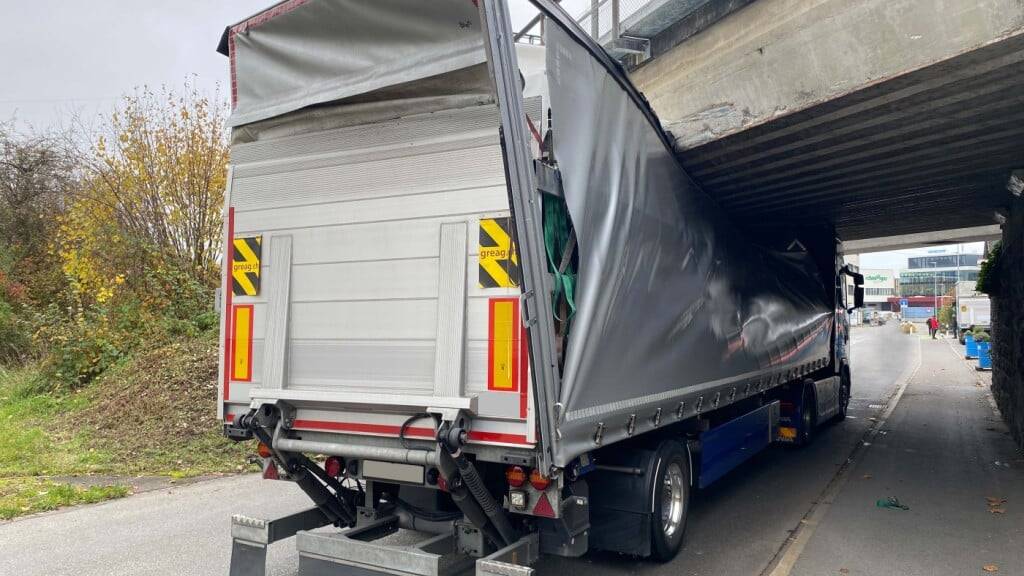 Im zugerischen Baar ist am Montagmittag ein Sattelmotorfahrzeug unter einer Brücke stecken geblieben. Herabfallende Fahrzeugteile verletzten einen Velofahrer erheblich.