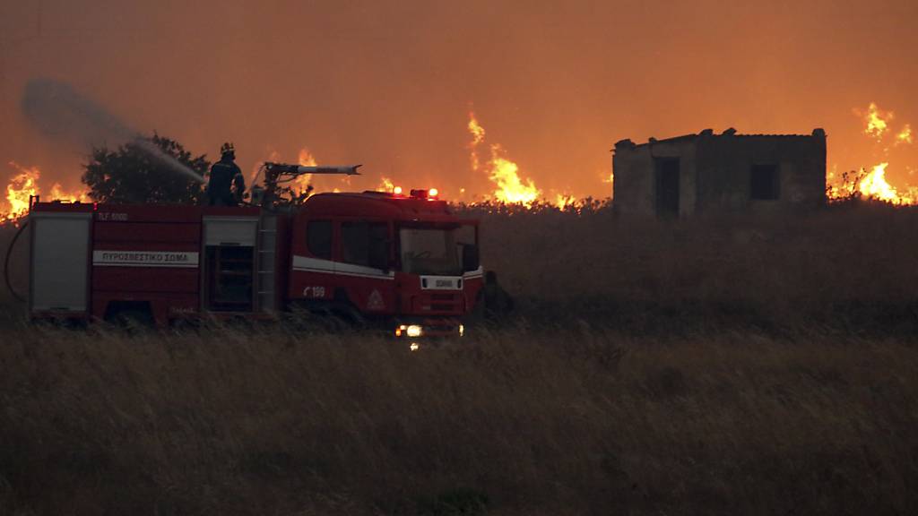 dpatopbilder - Ein Feuerwehrmann versucht einen Waldbrand zu löschen. Foto: Ilias Kotsireas/InTime News/AP/dpa