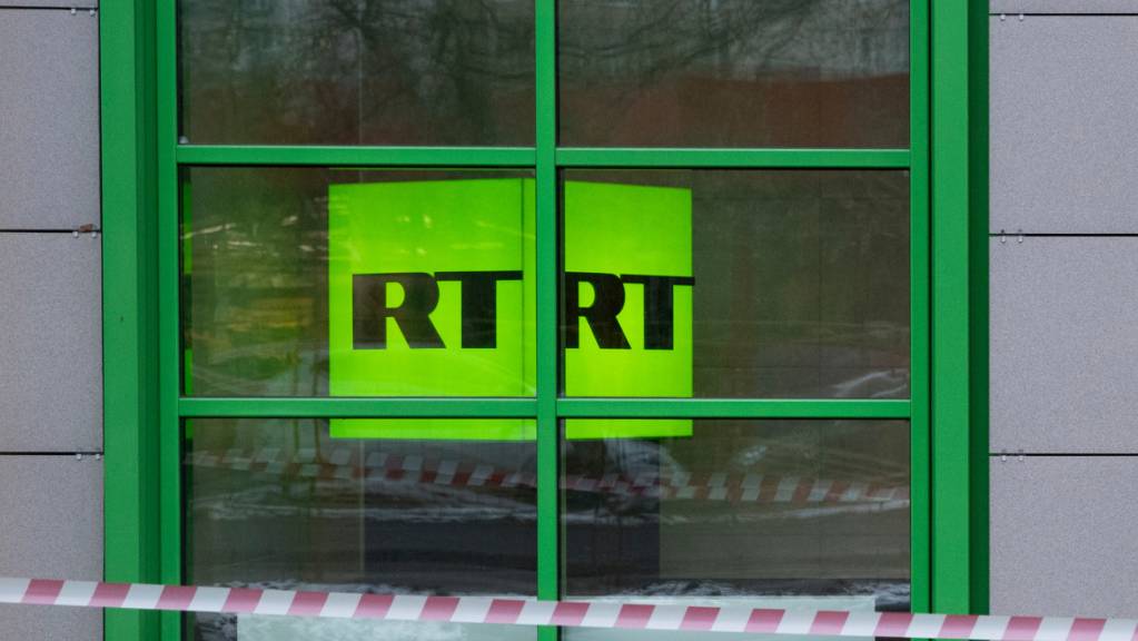 ARCHIV - Das Logo des staatlichen russischen TV-Senders «Russia Today» (RT) ist im Fenster eines Büros des Senders zu sehen. Das US-Programm des russischen Staatsmediums RT stellt seinen Betrieb in den Vereinigten Staaten ein. Das teilte die stellvertretende Chefredakteurin am Freitag mit. Foto: Pavel Golovkin/AP/dpa