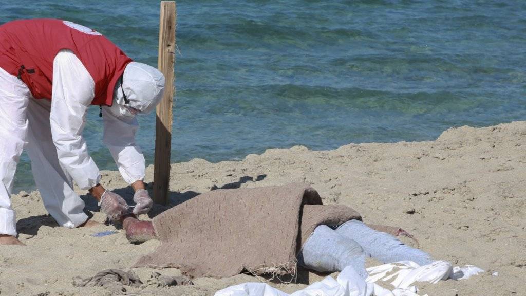 Ein libyscher Retter kümmert sich um eine der bisher 67 aus dem Mittelmeer geborgenen Leichen des Bootsunglücks vor der Hafenstadt Al-Chums.
