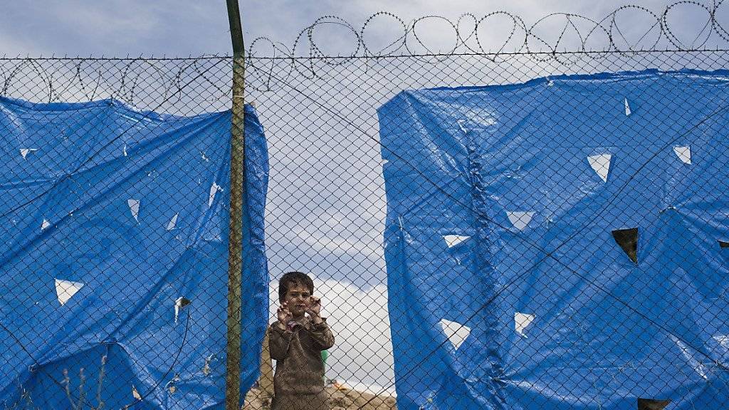 Seit der Schliessung der Balkanroute kommen weniger Asylsuchende in die Schweiz. Ein Teil der Schutzsuchenden bleibt in Griechenland hängen, wie dieser Junge in einem Camp in Athen. (Archivbild)