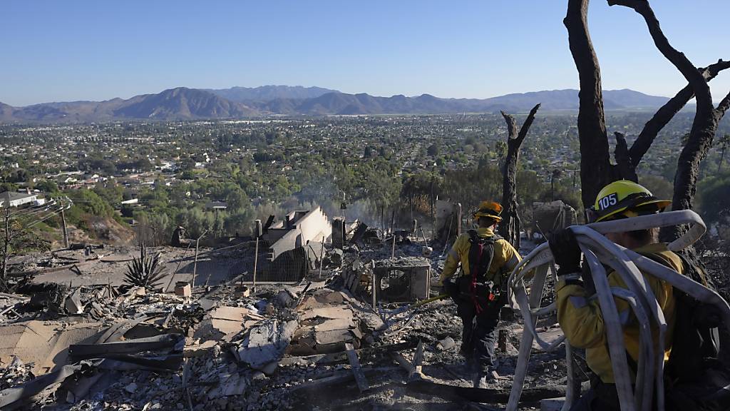 Feuerwehrleute arbeiten in einem vom Mountain Fire zerstörten Haus. Foto: Jae C. Hong/AP/dpa