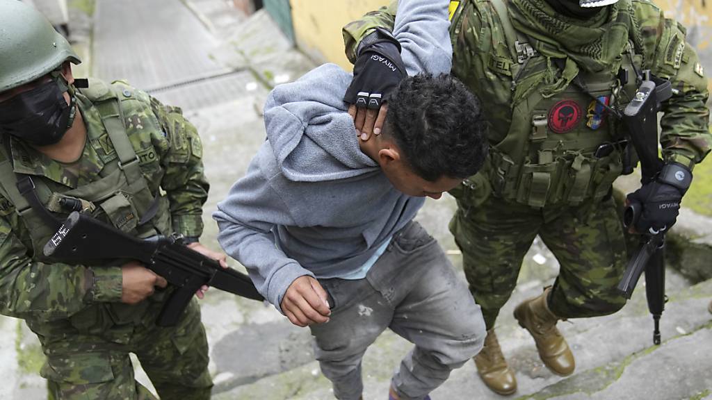 ARCHIV - Soldaten halten einen Jugendlichen fest und wollen überprüfen, ob er Tattoos aufweist, die im Zusammenhang mit einer Verbrecherbande stehen könnten. Nach einer Provokation der kriminellen Banden hatte Präsident Noboa 22 kriminelle Gruppen per Dekret als terroristische Organisationen deklariert. Foto: Dolores Ochoa/AP