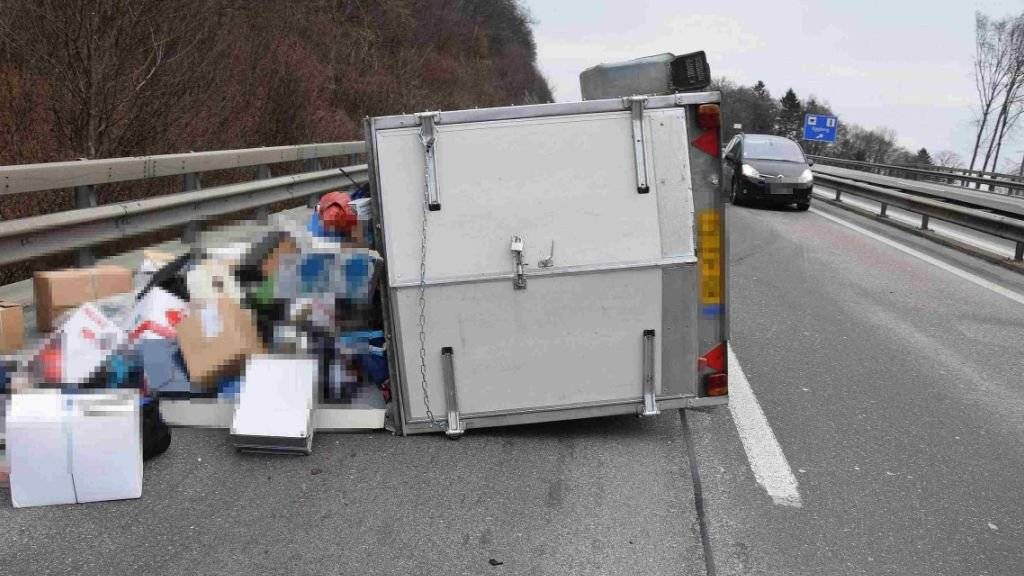 Bei einem Unfall ist auf der A2 hinter dem Belchentunnel in Richtung Luzern ein Autoanhänger umgekippt.