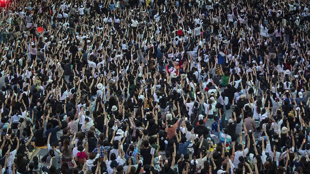 Demonstranten halten bei einem Protest drei Finger in die Höhe. Der Gruß gilt als Zeichen des Widerstands gegen die Militärregierung. Nach der jüngsten Großdemonstration in Bangkok erließ die Regierung in Thailand am Donnerstag eine Dringlichkeitsverordnung und verhängte ein Versammlungsverbot. Foto: Sakchai Lalit/AP/dpa