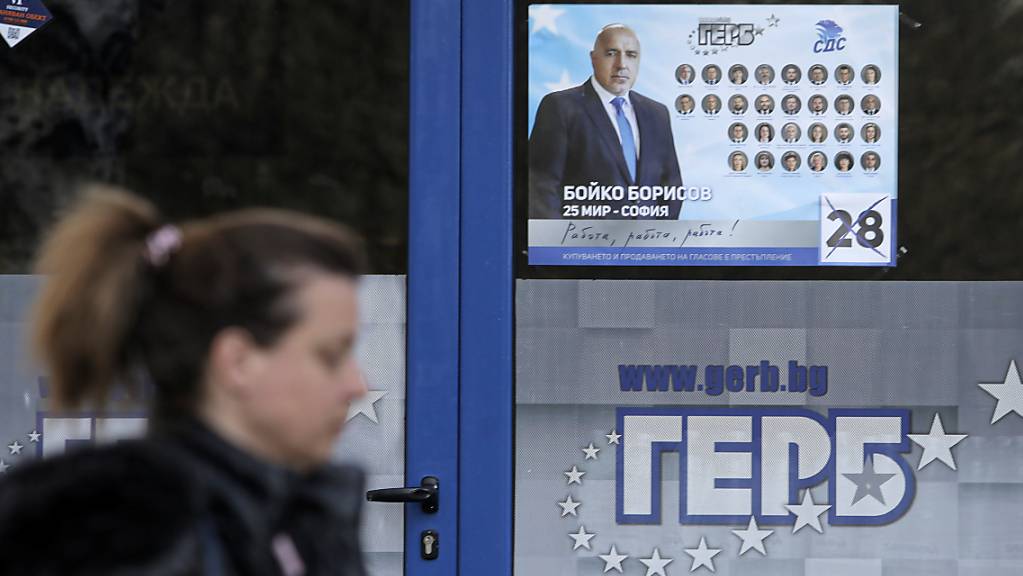 ARCHIV - Eine Frau geht an einem Plakat in Sofia vorbei, das den bulgarischen Premierminister Borissow zeigt. Foto: Valentina Petrova/AP/dpa