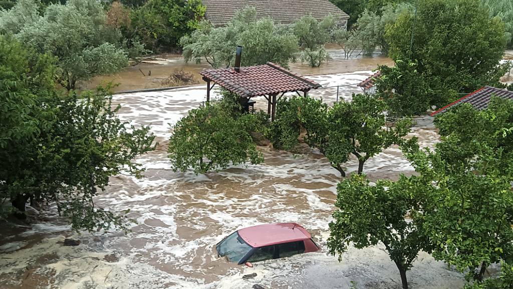 Ein Auto im Hochwasser im Dorf Milina in Pilion. Foto: Thanasis Kalliaras/Eurokinissi/AP/dpa