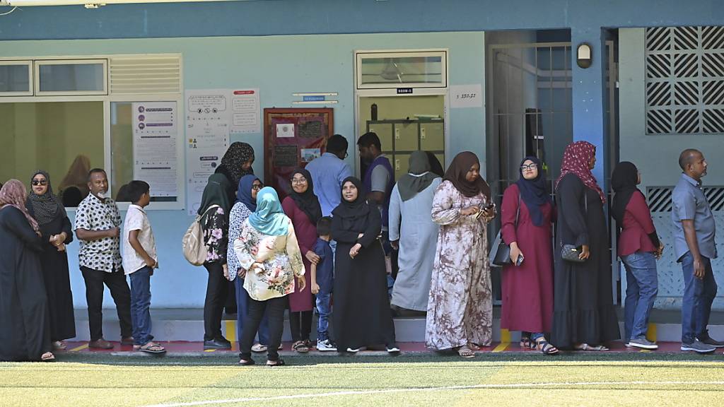 Menschen warten in einer Schlange vor einem Wahllokal in der maledivischen Hauptstadt Male, um ihre Stimme abzugeben. Foto: Mohamed Sharuhaan/AP/dpa
