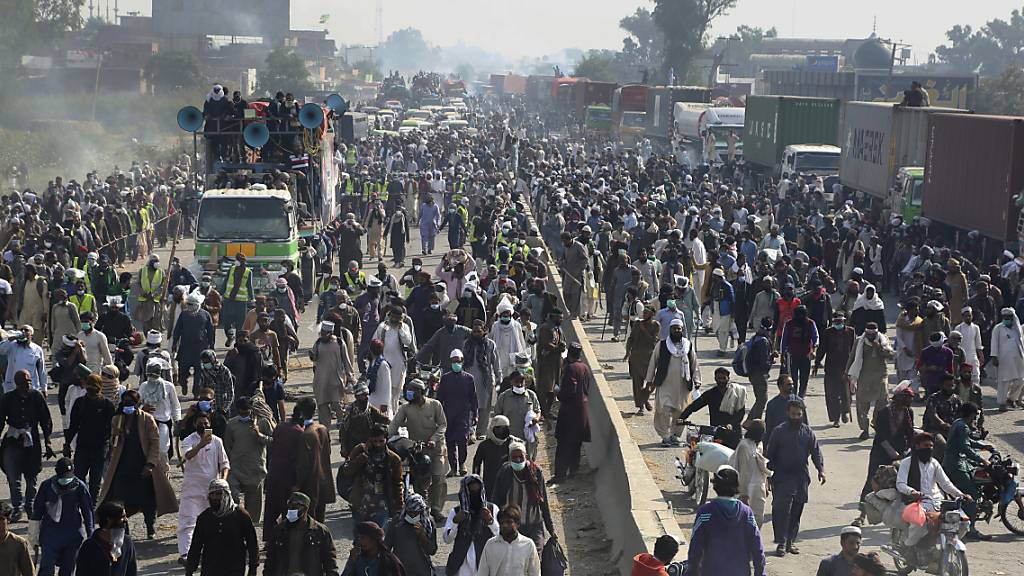 Anhänger der radikal-islamistischen Partei Tehreek-e Labbaik Pakistan (TLP) nehmen an einem Protestmarsch in Richtung Islamabad auf einer Landstraße teil. Foto: K.M. Chaudary/AP/dpa