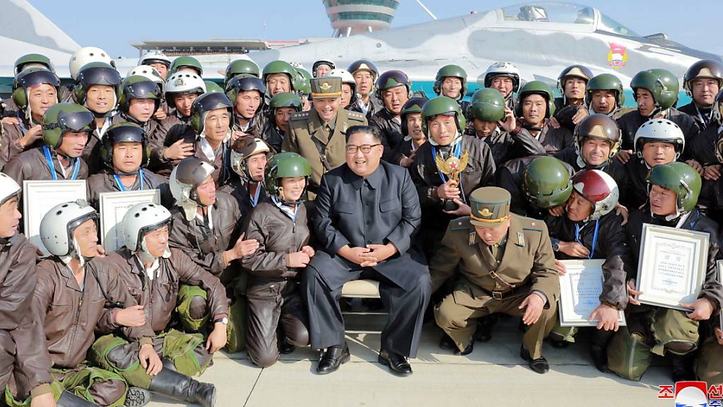 Nordkoreas Machthaber Kim Jong Un posiert mit Armeeangehörigen während Luftübungen der Streitkräfte.
