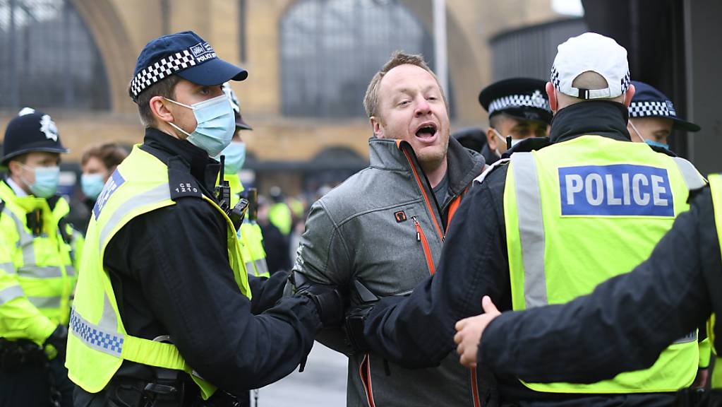 Ein Mann wird während einer Demonstration von Polizisten weggeführt. Foto: Stefan Rousseau/PA Wire/dpa