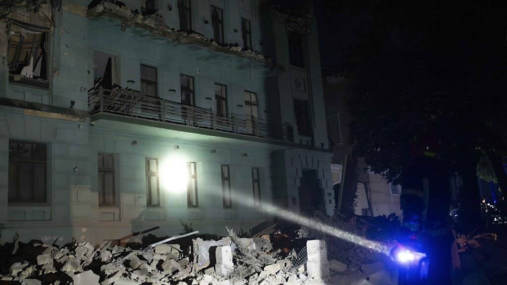 Ein Nothelfer begutachtet mit einer Taschenlampe die Schäden an einem Wohnhaus nach russischen Raketenangriffen in Odessa. Foto: Jae C. Hong/AP/dpa