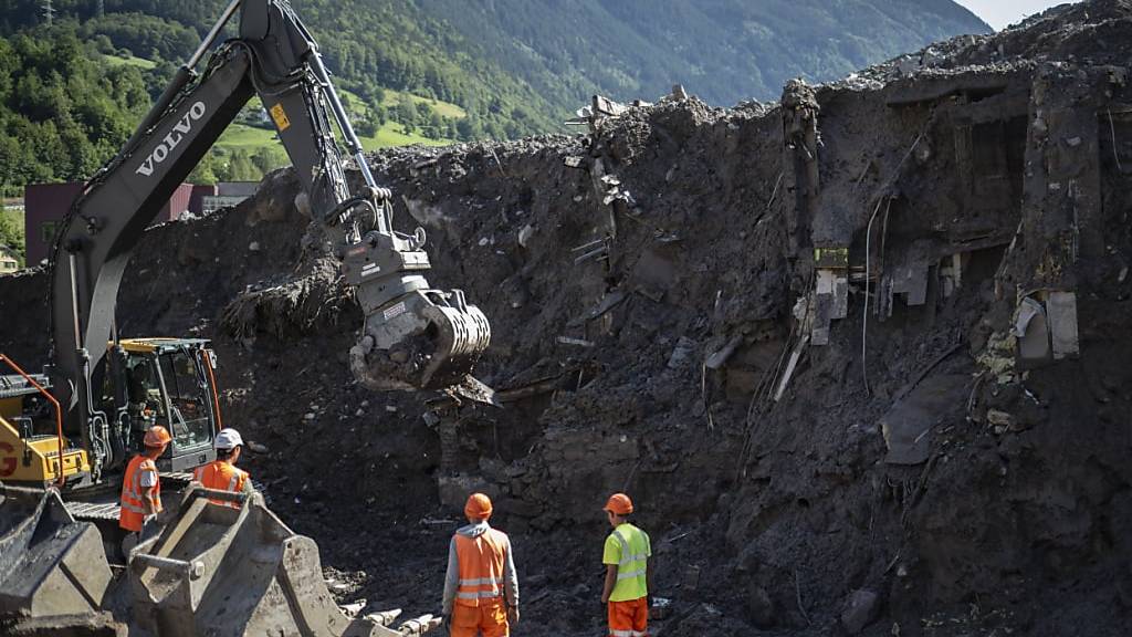 Die letzten verschütteten Häuser in Schwanden werden ein Jahr nach den Erdrutschen abgetragen. Parallel dazu wird ein Schutzdamm erstellt.