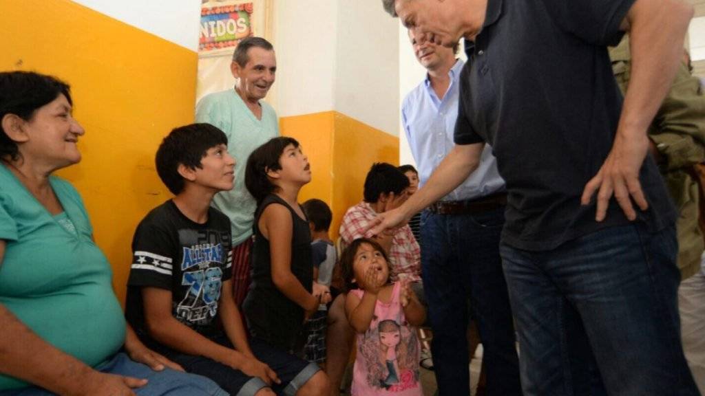 Argentiniens neugewählter Präsident Mauricio Macri bei Flutopfern. Sein Gehalt spendet er künftig für eine Suppenküche.