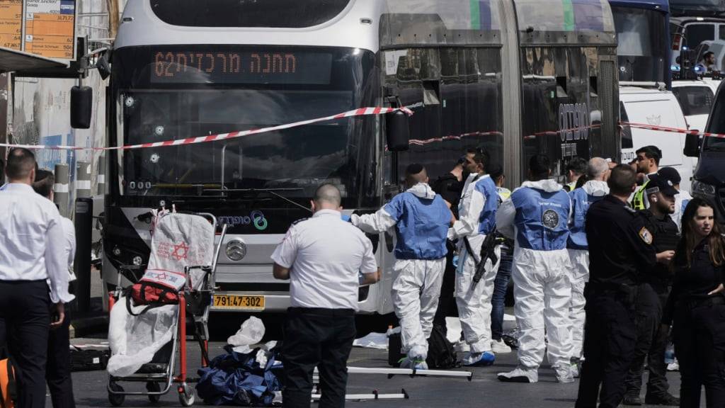 Israelische Polizisten und Rettungskräfte reagieren am Tatort eines Anschlags, bei dem mehrere Menschen in Jerusalem getötet und verletzt wurden. Foto: Mahmoud Illean/AP/dpa