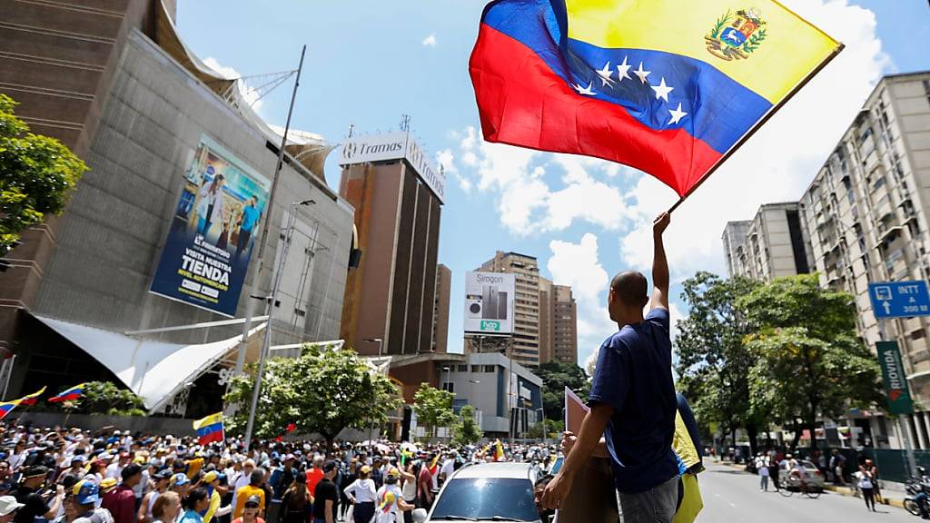 Demonstranten nehmen mit Flaggen Venezuelas an einer Kundgebung teil. Die Opposition hatte zu der Demonstration aufgerufen, um nach der Wahl gegen Präsident Maduro zu protestieren. Foto: Jeampier Arguinzones/dpa