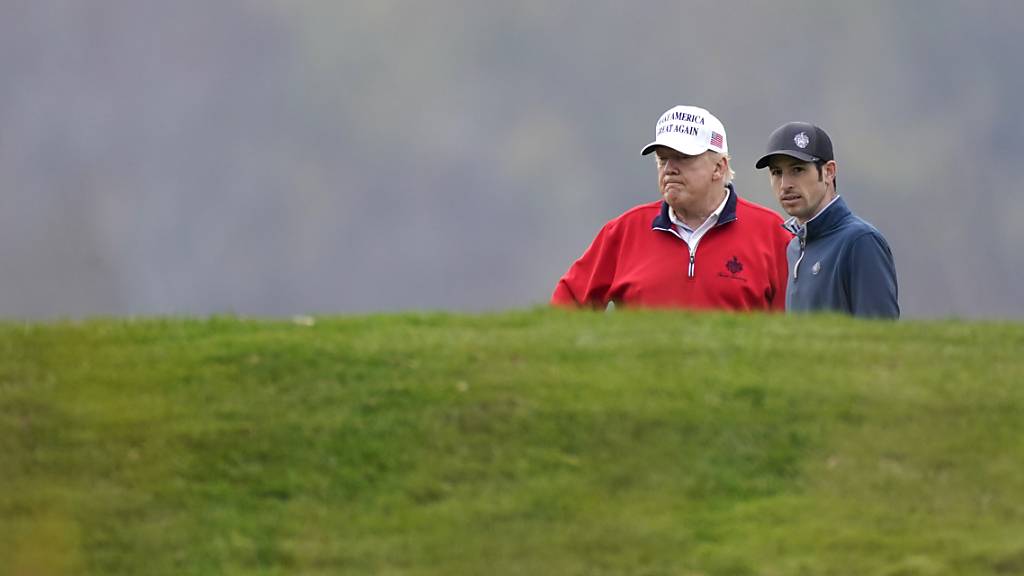 Donald Trump (l), amtierender Präsident der USA, spielt Golf im Trump National Golf Club in Sterling. Foto: Manuel Balce Ceneta/AP/dpa