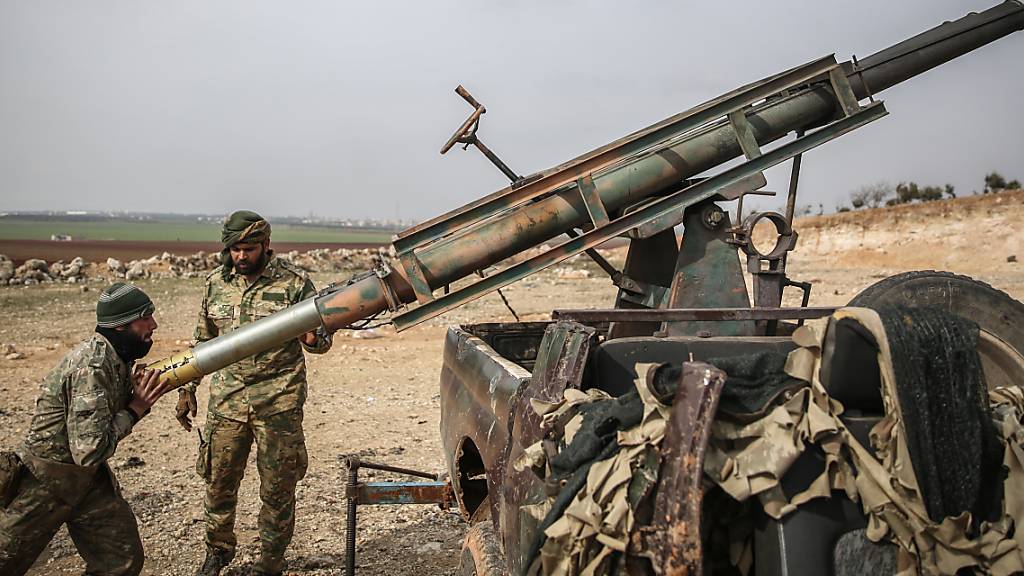 ARCHIV - Von der Türkei unterstützte Soldaten laden einen Raketenwerfer. Die vor fast zehn Jahren in Syrien ausgebrochenen Kämpfe sind 2020 weitgehend abgeklungen. Foto: Anas Alkharboutli/dpa