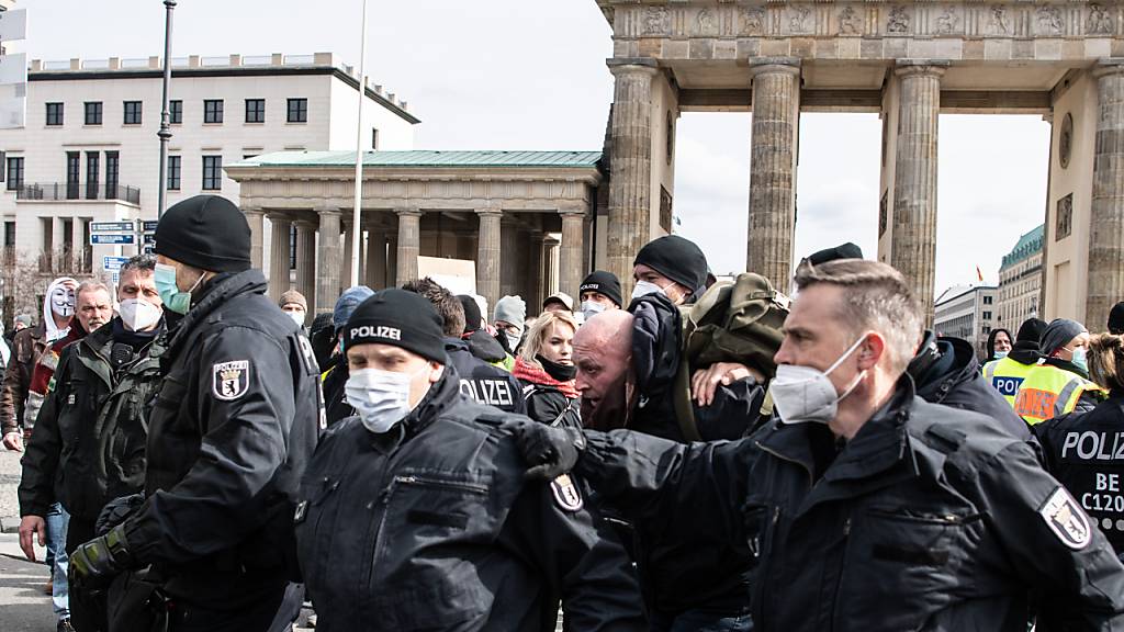 Ein Teilnehmer an einer Demonstration von Rechtsextremisten und sogenannten Reichsbürgern wird von der Polizei am Brandenburger Tor festgenommen. Foto: Paul Zinken/dpa