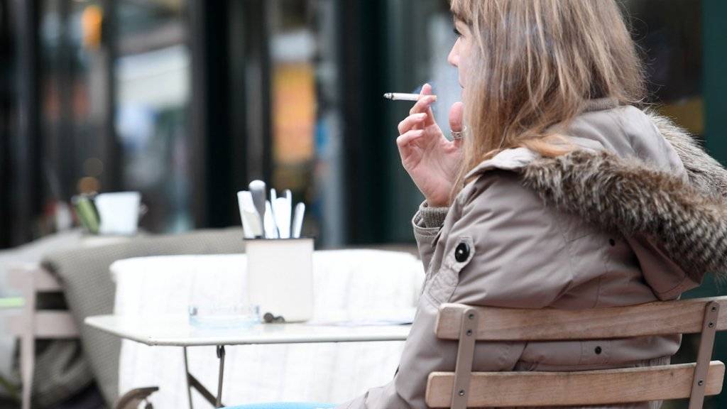 Frau mit Zigarette vor einem Restaurant in Wien.