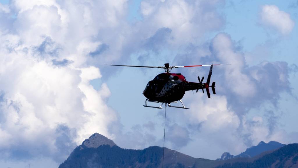 Symbolbild: Im Bild zu sehen ist ein Helikopter der Heli Rezia bei einem Transport im Gebirge.