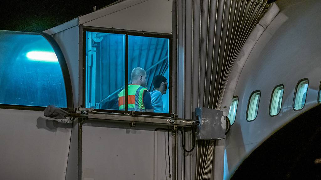 ARCHIV - Polizeibeamte begleiten einen Afghanen auf dem Flughafen Leipzig-Halle in ein Charterflugzeug. Deutschland schiebt vorerst keine Menschen mehr nach Afghanistan ab. Foto: Michael Kappeler/dpa