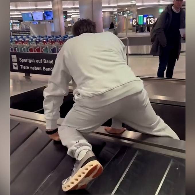 Ungeduldiger Elevator Boy klettert auf Gepäckband am Flughafen Zürich