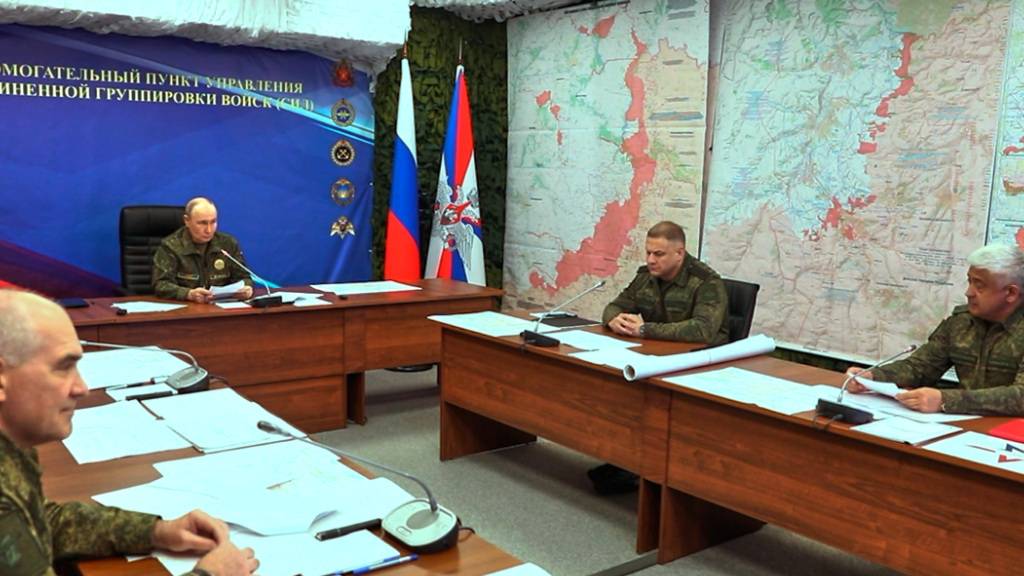 HANDOUT - Auf diesem Bild ist der russische Präsident Wladimir Putin (im Hintergrund in der Mitte) bei einem Besuch einer der Kommandozentralen der Gemeinsamen Gruppe der russischen Streitkräfte an einem nicht genannten Ort zu sehen. Foto: Uncredited/Russian Presidential Press Service via AP/dpa