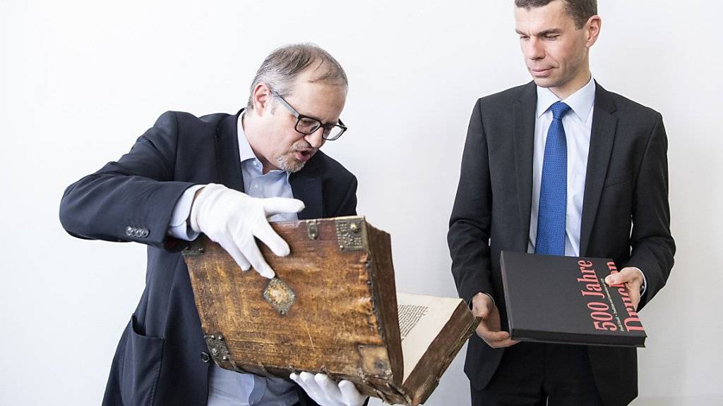 Prunkstücke aus dem Hause Orell Füssli: Historiker und Archivar Adrian Scherrer (links) hält eine Ausgabe der Zwingli-Bibel in seinen Händen, Martin Buyle CEO bei Orell Füssli, die Festschrift zum 500-Jahr-Jubiläum.