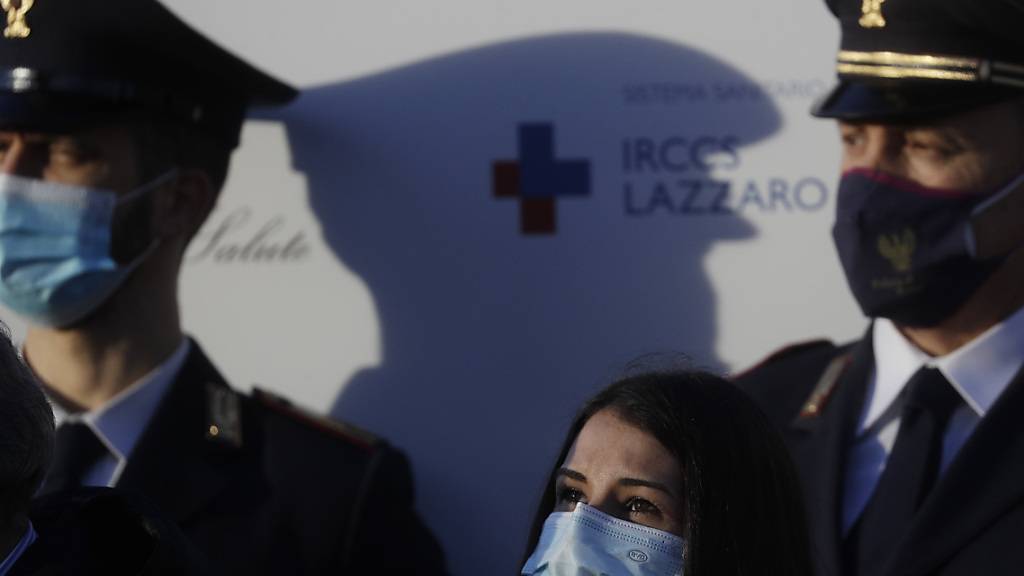 Die italienische Krankenschwester Claudia Alivernini (M) hat als erste Person in Italien den Corona-Impfstoff von Pfizer im Spallanzani Krankenhaus erhalten. Foto: Gregorio Borgia/AP/dpa