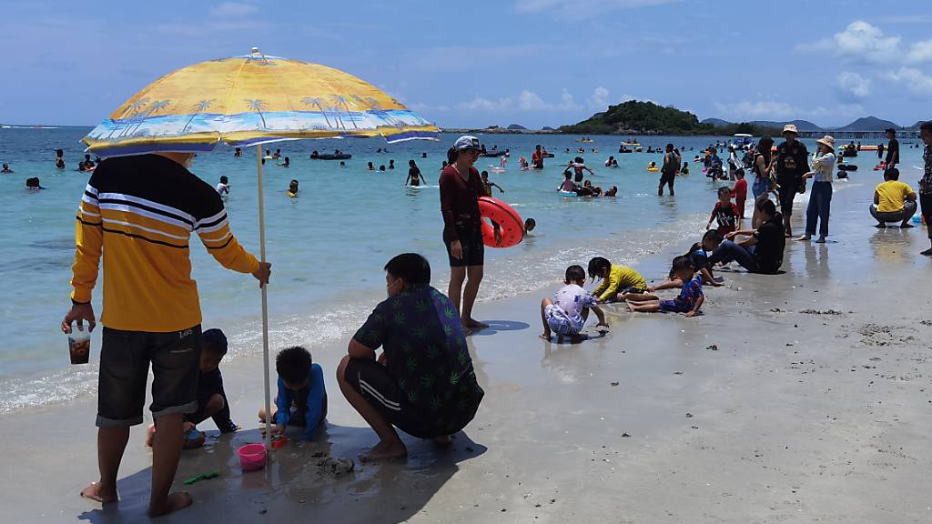 Einheimische und Touristen genießen die Zeit am Strand von Chonburi in Thailand.