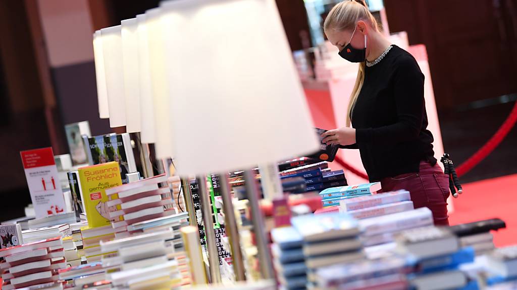 Eine Mitarbeiterin der Frankfurter Buchmesse steht vor der Eröffnungspressekonferenz der Frankfurter Buchmesse an einem Buchstand in der Festhalle. Foto: Arne Dedert/dpa pool/dpa