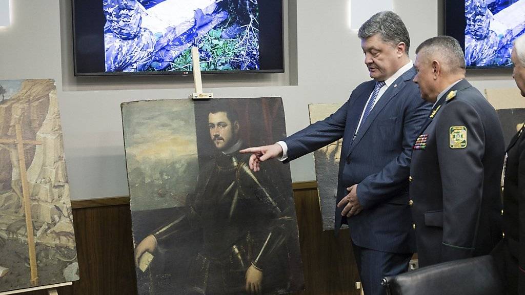 Der ukrainische Präsident Poroschenko begutachtet die sichergestellten Bilder.