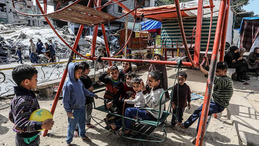 ARCHIV - Vertriebene palästinensische Kinder spielen auf einer Schaukel im Lager Shaboura, während die israelischen Luftangriffe andauern. Foto: Abed Rahim Khatib/dpa