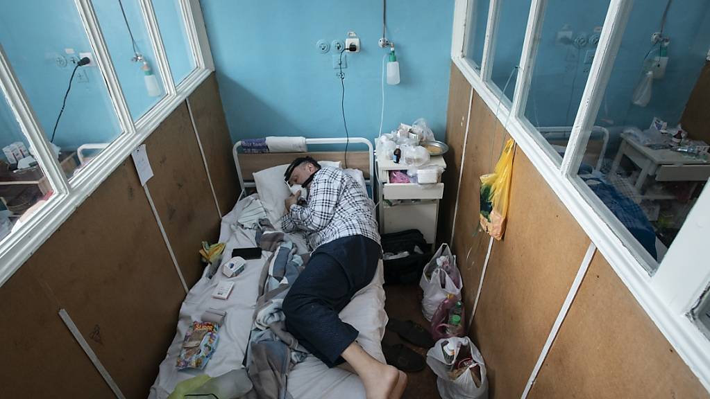 Ein Patient, der mit dem Coronavirus infiziert ist, atmet mit Hilfe einer Sauerstoffmaske auf der Intensivstation im regionalen Krankenhaus.